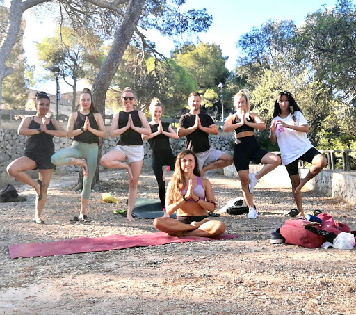 group of people doing yoga on the beach